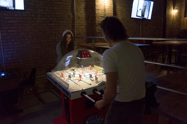 Ryan Duclos sharing a game of bubble hockey with Emily Gualdoni.
